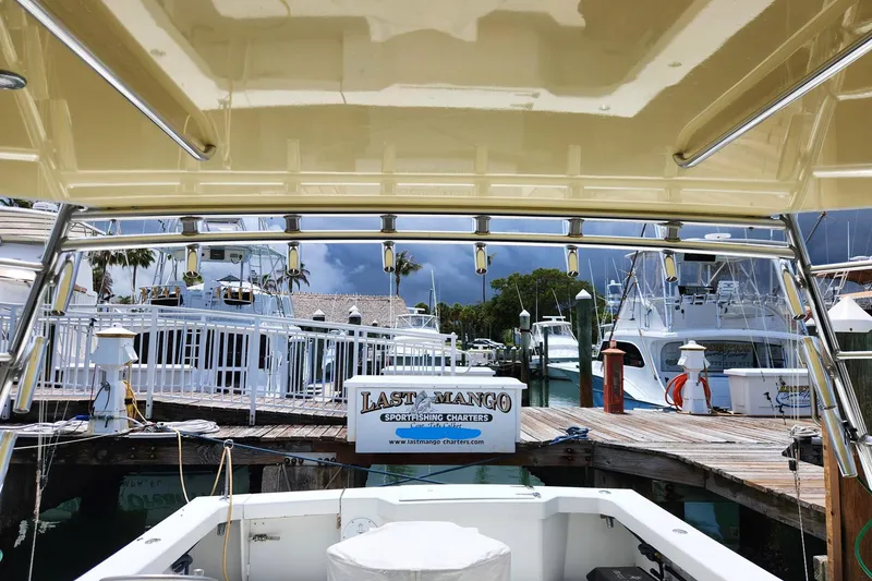 Slide: The Image of 1987 Young Brothers Custom Sport Fish boat docked at marina with stormy sky. - 13