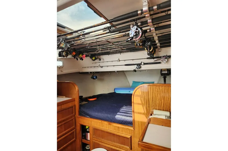 Slide: The Image of Interior of 1987 Young Brothers Custom Sport Fish boat with fishing rods and cozy bed. - 16