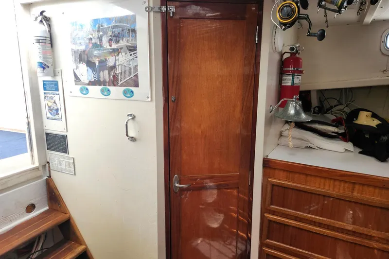 Slide: The Image of Interior of 1987 Young Brothers Custom Sport Fish boat with wooden door and fishing gear. - 17