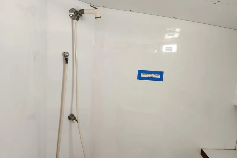 Slide: The Image of Shower area in 1987 Young Brothers Custom Sport Fish boat with caution sign. - 19
