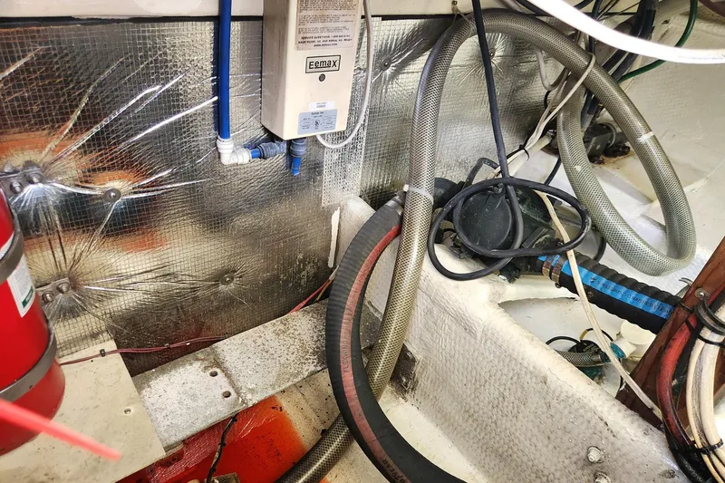 Slide: The Image of Engine room of 1987 Young Brothers Custom Sport Fish boat with hoses and equipment. - 25