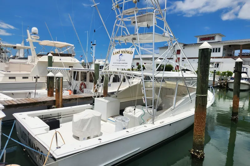 Slide: The Image of 1987 Young Brothers Custom Sport Fish boat docked at marina under clear blue sky. - 4