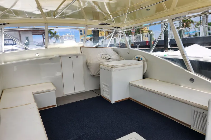 Slide: The Image of 1987 Young Brothers Custom Sport Fish boat interior with seating and helm, docked at marina. - 5