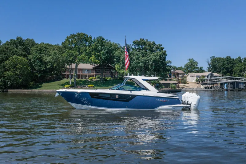 The Image of 2027 Monterey 385SS Super Sport boat on a serene lake with lush greenery. - 1