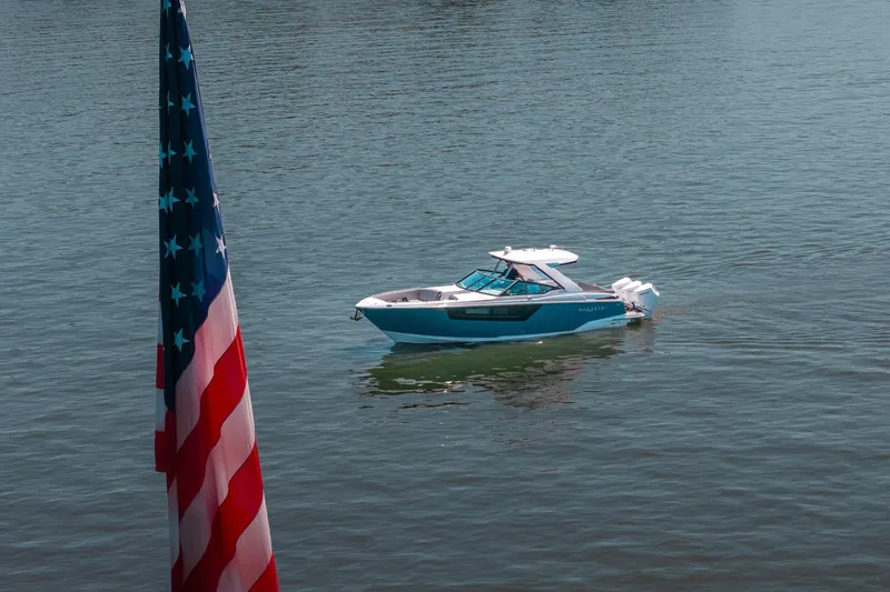 Slide: The Image of A 2027 Monterey 385SS Super Sport boat on water, with an American flag in the foreground. - 11
