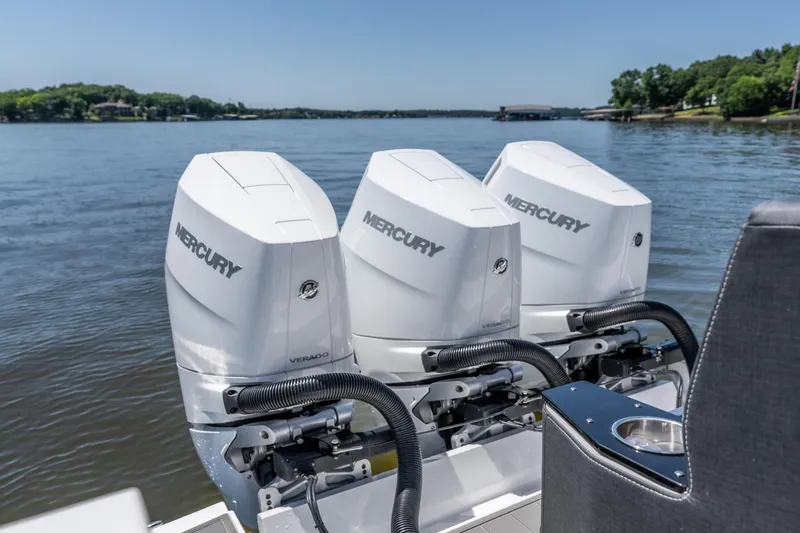 Slide: The Image of Triple Mercury outboard engines on a 2027 Monterey 385SS Super Sport boat, on a serene lake. - 17