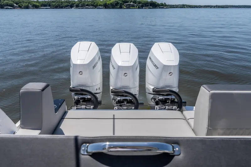 Slide: The Image of 2027 Monterey 385SS Super Sport boat with triple Mercury outboard engines on a calm lake. - 18