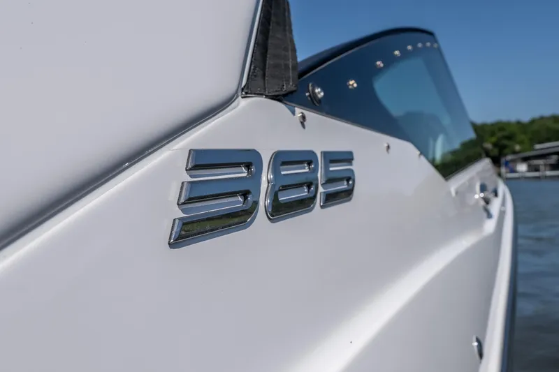 Slide: The Image of 2027 Monterey 385SS Super Sport boat, sleek design with chrome emblem, on water. - 19