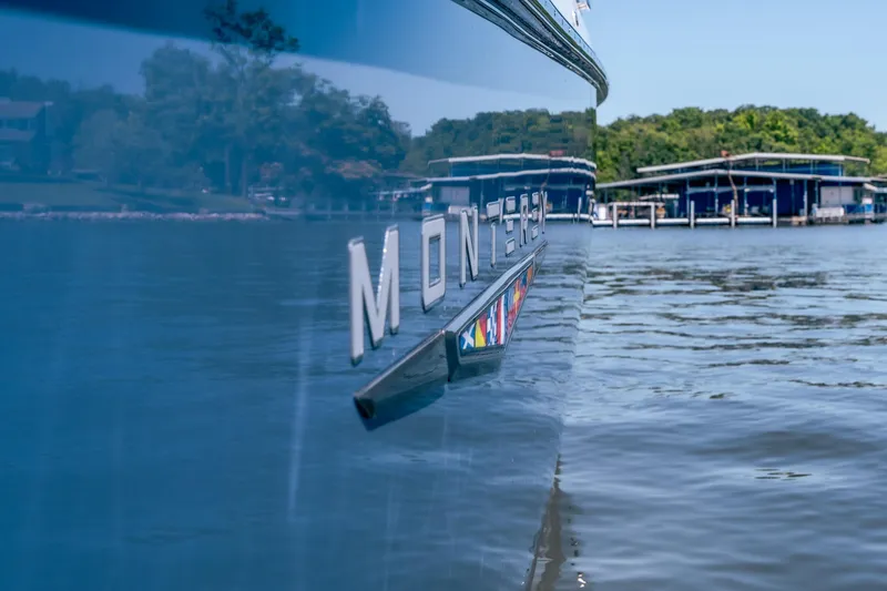 Slide: The Image of 2027 Monterey 385SS Super Sport boat on calm water near a marina. - 20