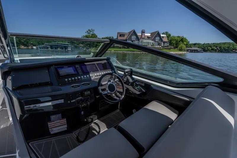 Slide: The Image of Cockpit view of 2027 Monterey 385SS Super Sport boat on a serene lake. - 26