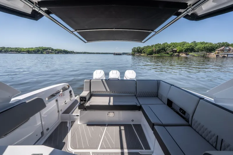 Slide: The Image of 2027 Monterey 385SS Super Sport boat interior with spacious seating on a calm lake. - 31