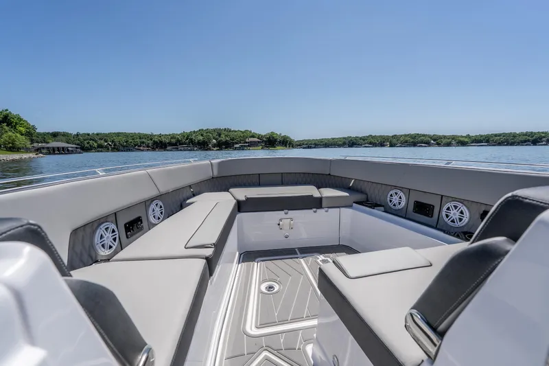 Slide: The Image of 2027 Monterey 385SS Super Sport boat interior with luxurious seating on a serene lake. - 33