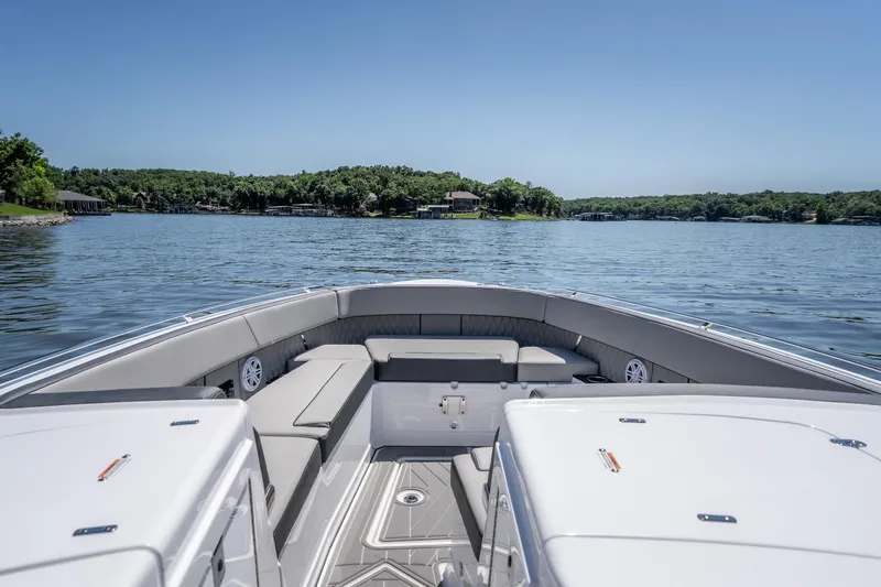Slide: The Image of 2027 Monterey 385SS Super Sport boat on a serene lake with lush green shoreline. - 42