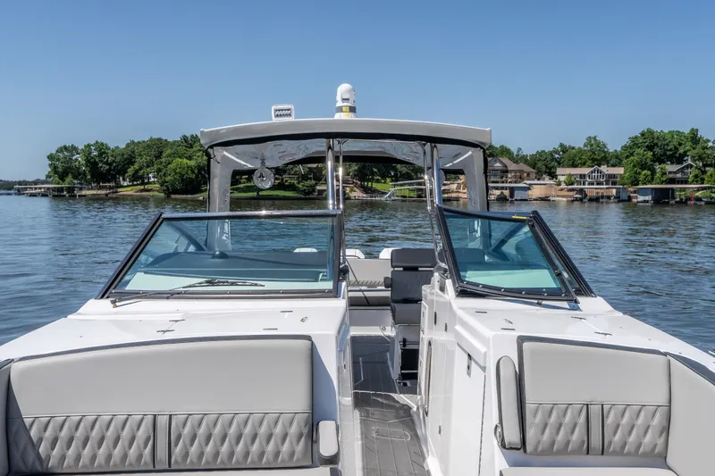 Slide: The Image of 2027 Monterey 385SS Super Sport boat on a serene lake with clear blue skies. - 47