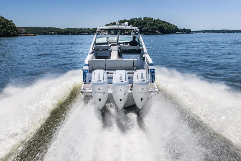 Slide: The Image of 2027 Monterey 385SS Super Sport boat cruising on a lake with triple engines. - 5
