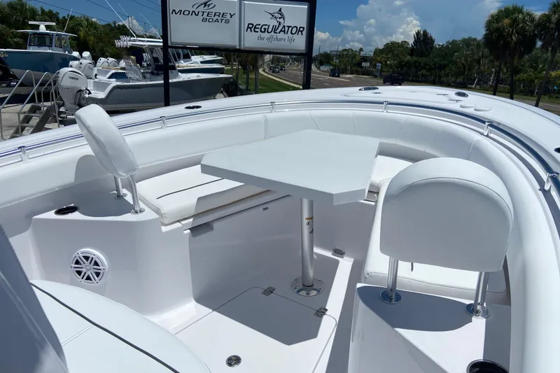 Slide: The Image of 2026 Sportsman Heritage 231 Center Console boat with seating and table, displayed outdoors. - 33
