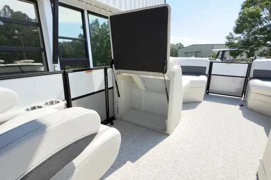 Slide: The Image of 2026 Coach Pontoons 223 RFC interior with open storage compartment and seating. - 15