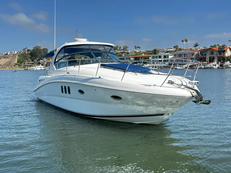The Image of A white motorboat, Sea Ray 380 Sundancer, floats on calm water in a harbor. - 0