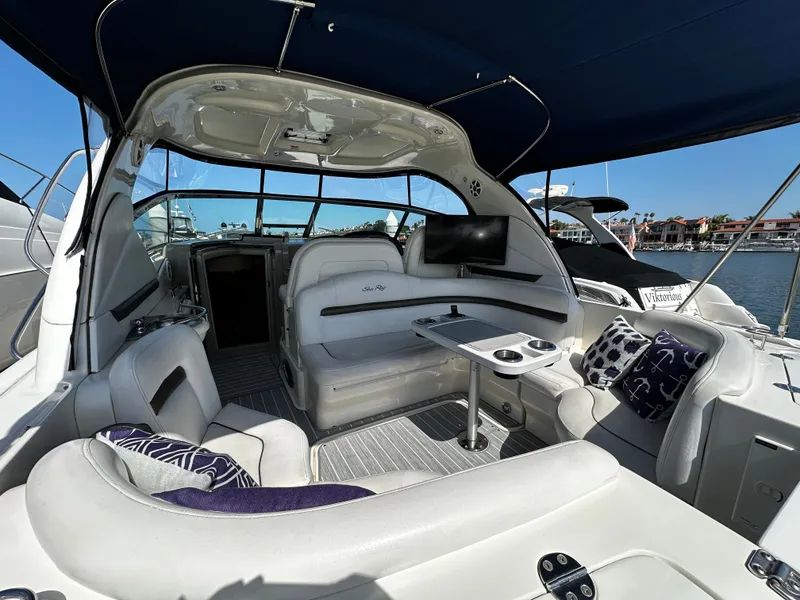 Slide: The Image of The interior of a 2006 Sea Ray 380 Sundancer with white seating and a table. - 14
