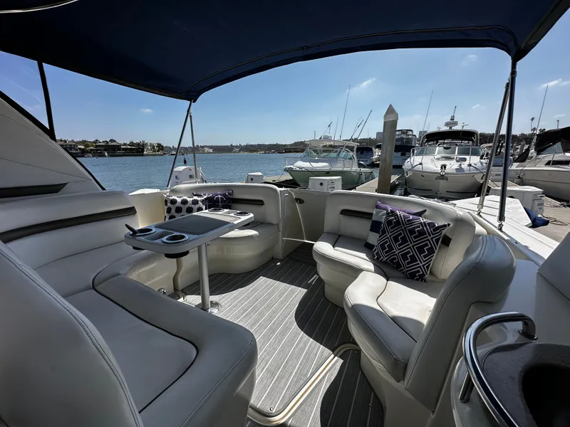 Slide: The Image of The interior of a Sea Ray 380 Sundancer with sleek seating and cushions, docked at a marina. - 15