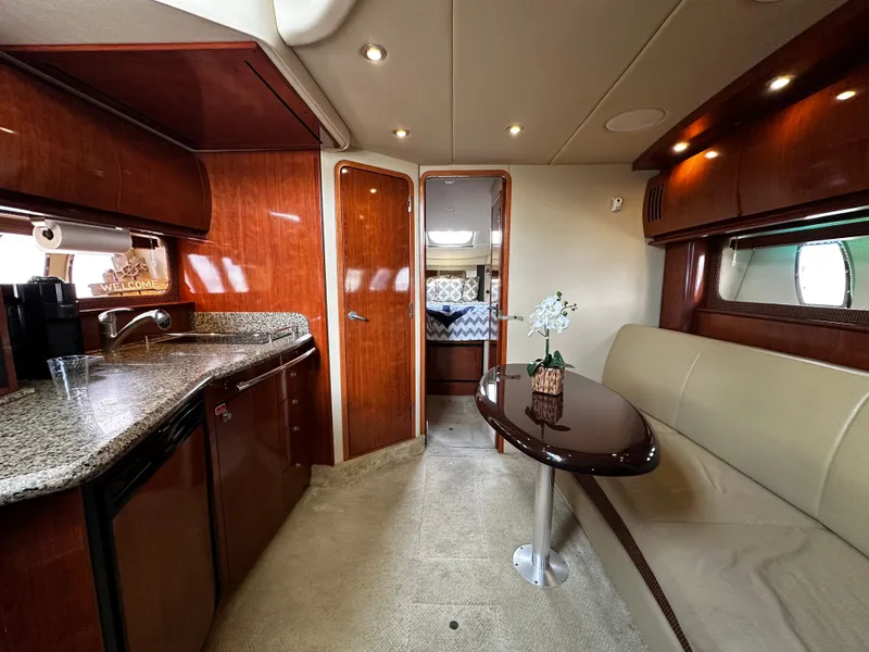 Slide: The Image of Interior of a Sea Ray 380 Sundancer with elegant wood finishes and a cozy seating area. - 16