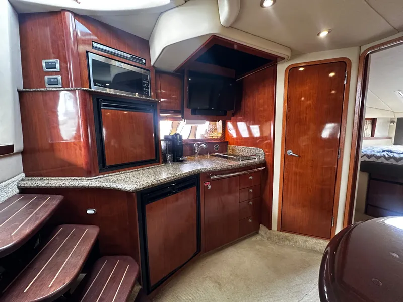 Slide: The Image of Interior of a Sea Ray 380 Sundancer with wood furnishings and kitchenette. - 18
