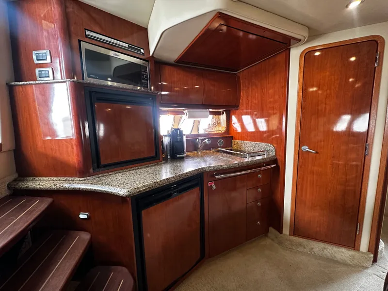 Slide: The Image of The galley of a 2006 Sea Ray 380 Sundancer with wood cabinets and granite countertop. - 19