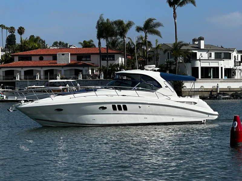 Slide: The Image of A white motorboat cruises on calm water near a shoreline with palm trees. - 2