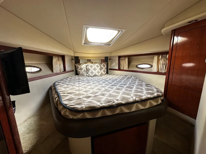 Slide: The Image of The interior of a 2006 Sea Ray 380 Sundancer features a cozy bedroom with a skylight. - 24