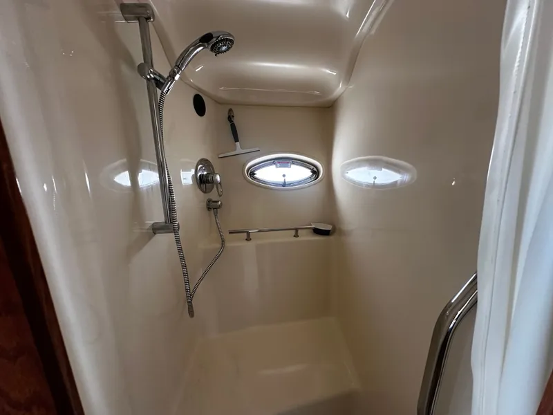 Slide: The Image of A shower cabin with a handheld showerhead and porthole on a boat. - 26