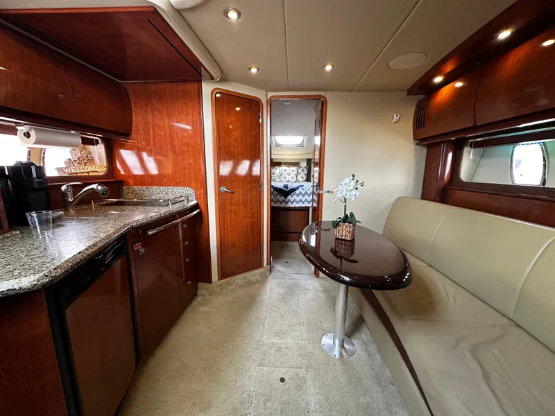 Slide: The Image of Luxurious yacht interior with kitchen, sofa, and table, warmly lit. - 27
