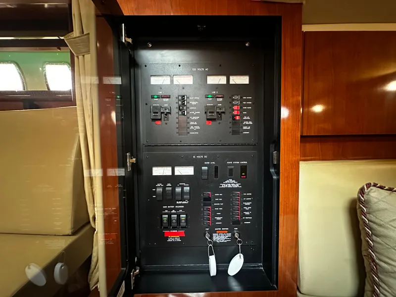 Slide: The Image of Electrical control panel on a Sea Ray 380 Sundancer yacht, surrounded by wooden furnishings. - 28