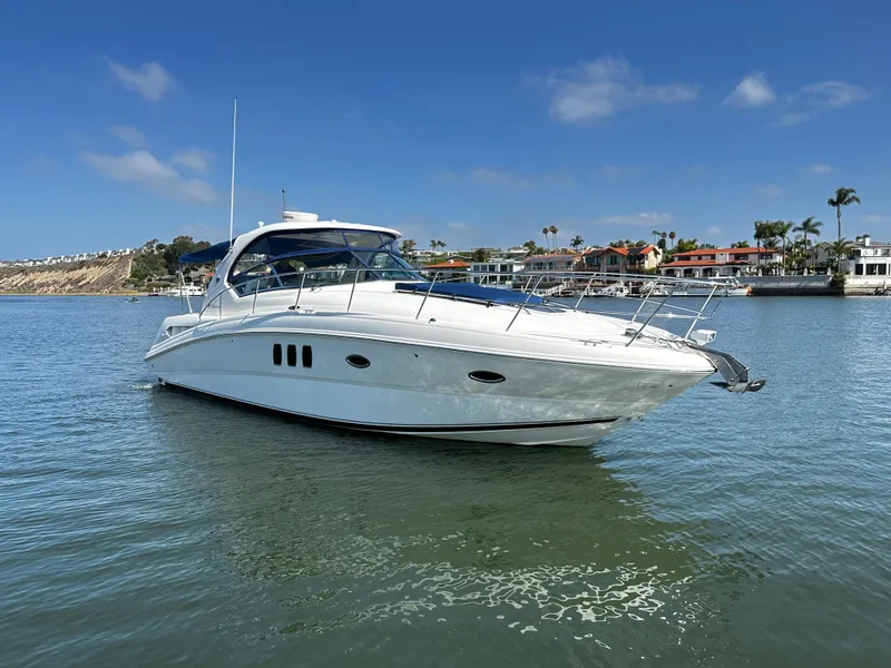 Slide: The Image of A white motorboat on calm water near a shoreline with houses. - 3