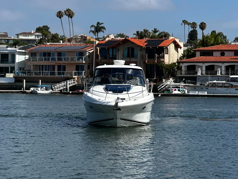 Slide: The Image of A white motorboat cruises on calm water in front of a row of houses. - 4