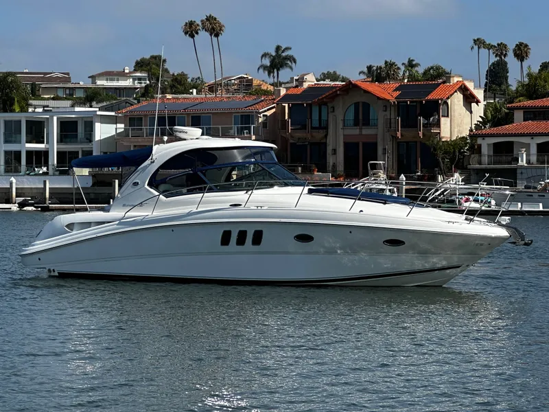 Slide: The Image of A white motorboat cruises on calm water near a coastal town with palm trees. - 5