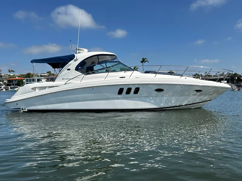 Slide: The Image of A white motorboat with a blue cover floats on calm water under a blue sky. - 9