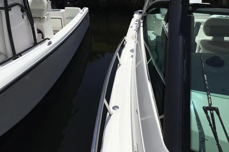 Slide: The Image of 2013 Everglades 320EX boat docked beside another vessel, showcasing sleek design. - 18