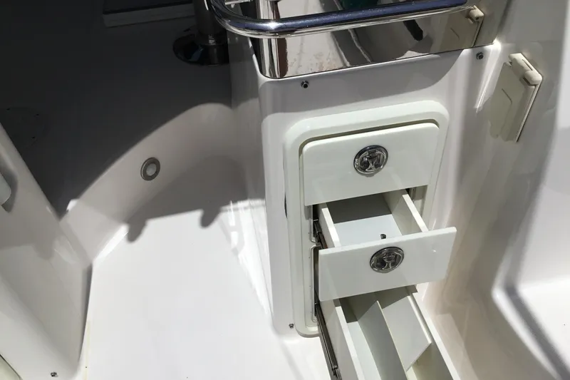 Slide: The Image of 2013 Everglades 320EX boat interior with open storage drawers and stainless steel railing. - 32