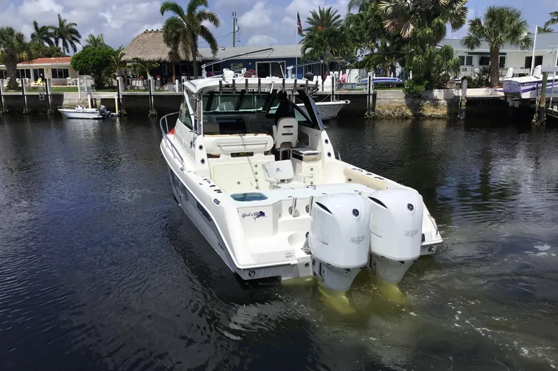 Slide: The Image of 2013 Everglades 320EX boat with dual engines on a sunny waterfront. - 9