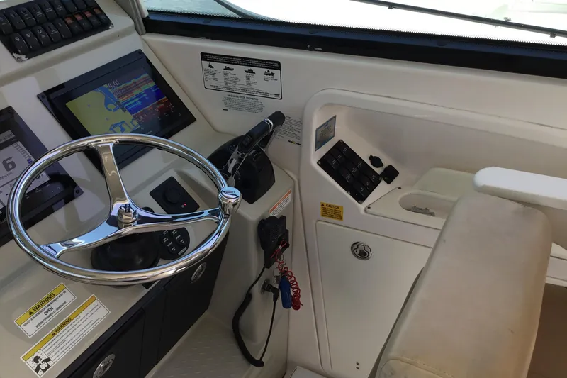 Slide: The Image of Helm of 2013 Everglades 320EX boat with steering wheel and navigation controls. - 27