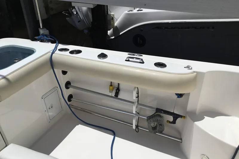 Slide: The Image of 2013 Everglades 320EX boat interior with fishing rod holders and storage compartments. - 33
