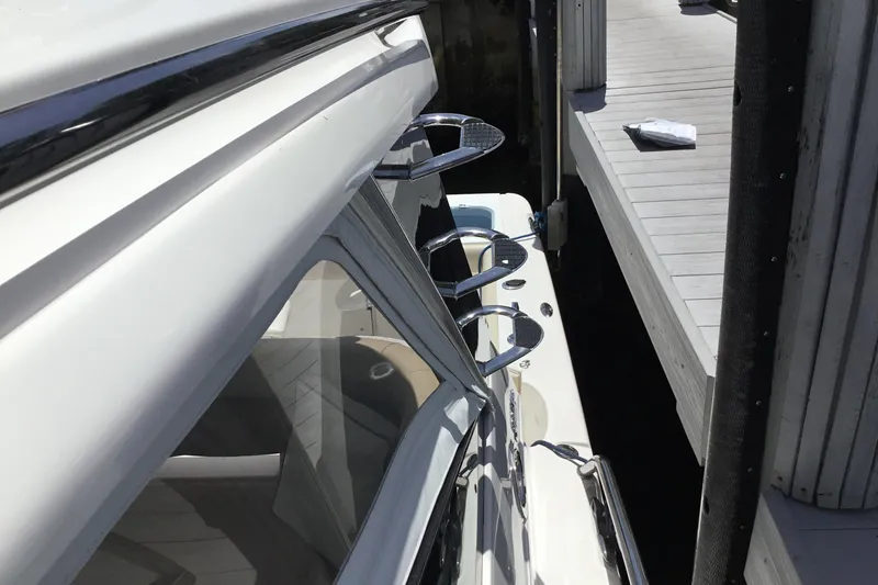 Slide: The Image of 2013 Everglades 320EX boat docked, showcasing sleek design and fishing rod holders. - 20
