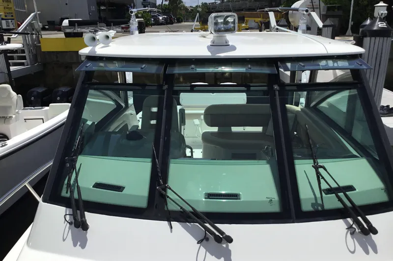 Slide: The Image of 2013 Everglades 320EX boat with windshield wipers and cabin view at a marina. - 13