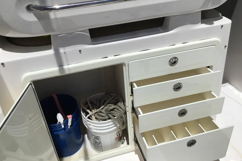 Slide: The Image of Storage compartment on a 2013 Everglades 320EX boat with buckets and rope. - 31