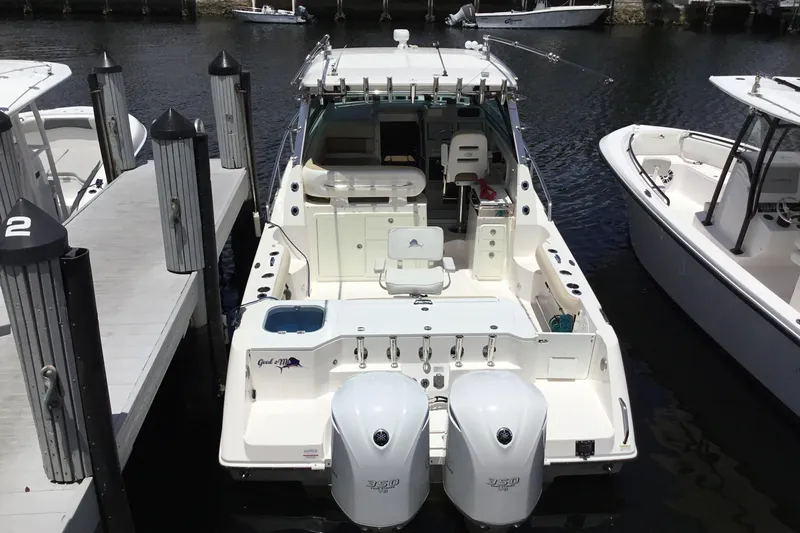 Slide: The Image of 2013 Everglades 320EX boat docked, featuring twin engines and spacious deck layout. - 59