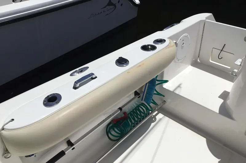 Slide: The Image of 2013 Everglades 320EX boat deck with rod holders and coiled hose. - 35
