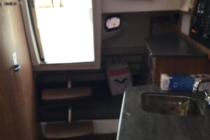 Slide: The Image of Interior of a 2013 Everglades 320EX boat featuring a compact kitchen area. - 55