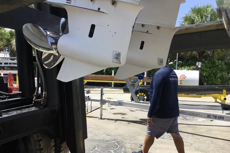 Slide: The Image of Man walking near Everglades 320EX boat propellers, 2013 model, in a marina setting. - 61