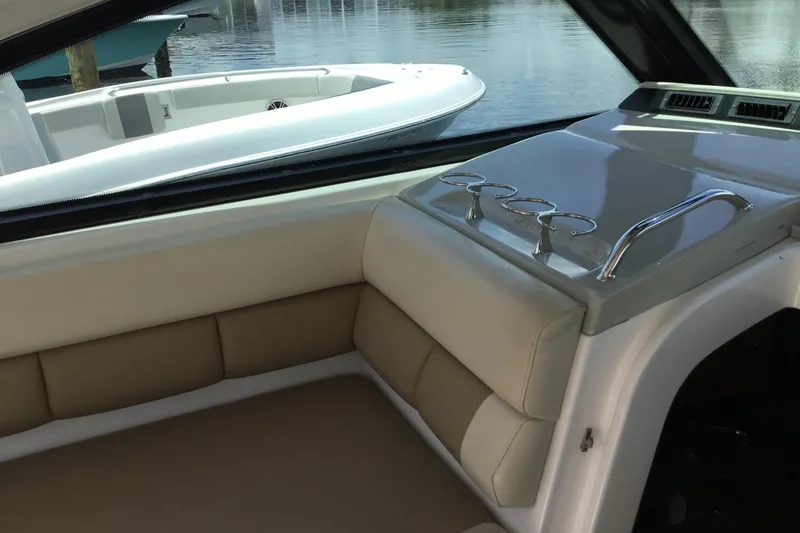 Slide: The Image of Interior of a 2013 Everglades 320EX boat with beige seating and cup holders. - 24