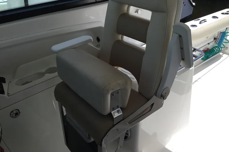 Slide: The Image of Captain's chair on a 2013 Everglades 320EX boat, featuring cushioned seating and armrests. - 44